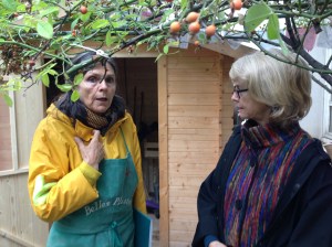 Anne et Suzanne devant la cabane de jardin où sont entreposés bottes, outils, brouette, etc...